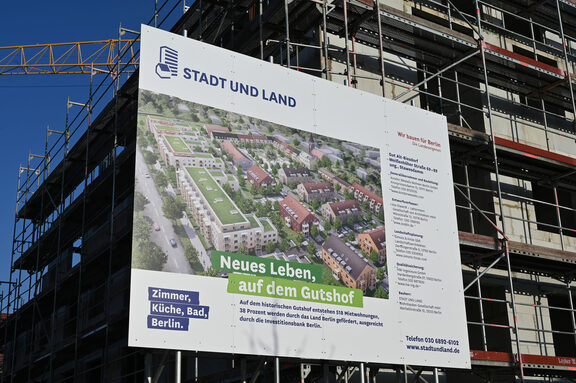 Bauschild des neuen Wohnquartiers der STADT UND LAND "Gut Alt-Biesdorf" vor dem entsprechenden Rohbau.