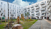 Das Foto zeigt eine Aufnahme vom Hof mit Spielplatz des neuen Hauses der STADT UND LAND in der Pöhlbergstraße.